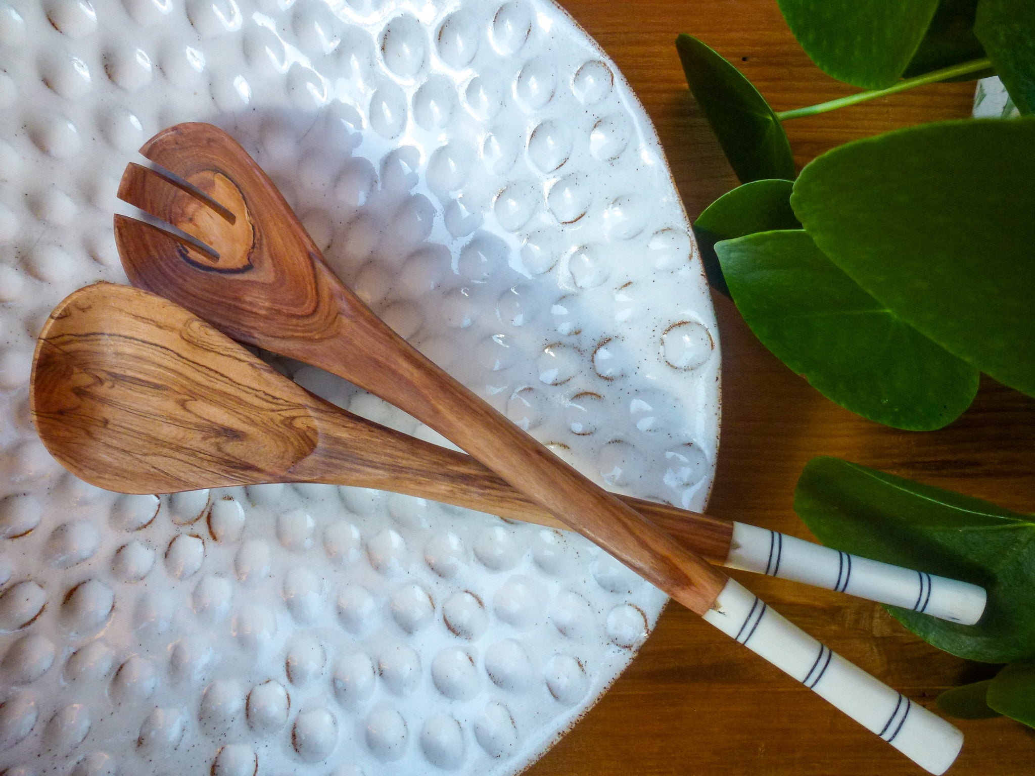 African salad servers made of wood and horn in white fruit bowl
